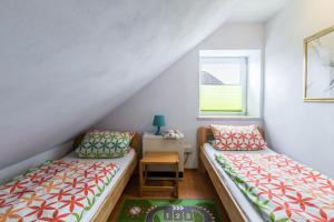 two beds in a room with a table and a window at Ferienhaus Kikki in Friedrichskoog-Spitze