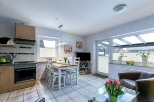 a kitchen and living room with a table and chairs at Ferienhaus Kikki in Friedrichskoog-Spitze +17 photos