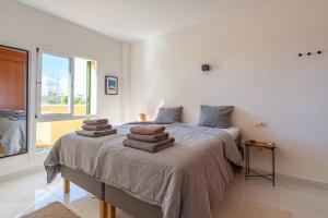 a bedroom with a bed with towels on it at Lovely Apartment Higueron in Benalmádena +14 photos