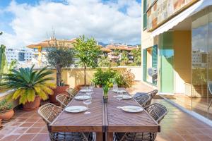 a wooden table on a balcony with chairs and a table at Lovely Apartment Higueron in Benalmádena