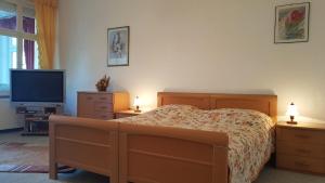 a bedroom with a bed and a flat screen tv at Villa Adler- Seeblick in Ahlbeck