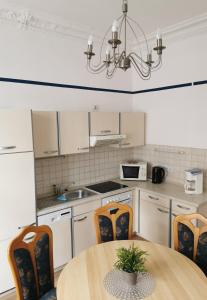 a kitchen with a table and chairs and a chandelier at Villa Adler- Seeblick in Ahlbeck