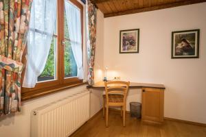 a chair sitting at a desk in a room with a window at Ferienwohnung Risthof 4 in Owingen +21 photos