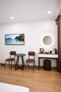 a room with two chairs and a table and a mirror at Dreamora Centre Hotel in Hanoi