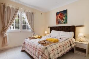 a bedroom with a bed with a blanket and a window at Casa Colleen in Puerto del Carmen +22 photos