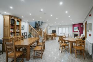 a dining room with tables and chairs and a staircase at El Humilladero in Sasamón