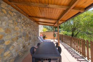 a patio with a table and a stone wall at Oltremare in Riparbella