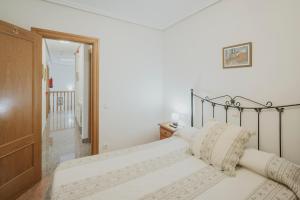 a white bedroom with a bed with a metal frame at El Humilladero in Sasamón