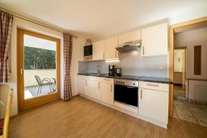 a kitchen with white cabinets and a stove top oven at Ferienhaus Maria Arnika in Moso