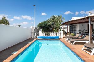 a swimming pool in the backyard of a house at Casa Colleen in Puerto del Carmen