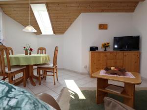 a kitchen and dining room with a table and a tv at Ferienwohnung Haus Doris in Rickenbach