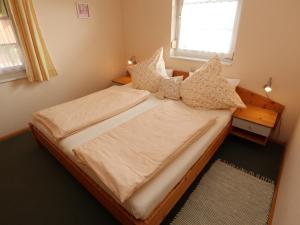 a bedroom with a bed with pillows and a window at Ferienwohnung Haus Doris in Rickenbach