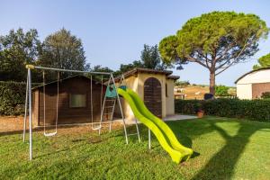 a playground with a slide in a yard at Capracotta - Alba in Montemassi