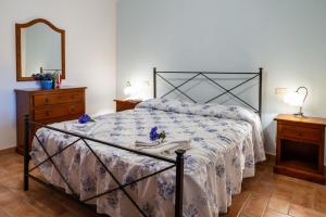 a bedroom with a bed and a dresser and a mirror at Capracotta - Alba in Montemassi +27 photos