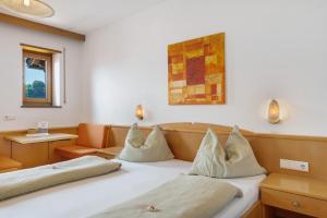 a hotel room with a bed with pillows at Seaberhof Kaltern in Caldaro +91 photos