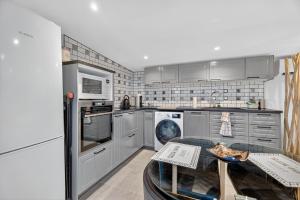 a kitchen with stainless steel appliances and a table at Cabanon des Amandiers avec terrasse in Sanary-sur-Mer
