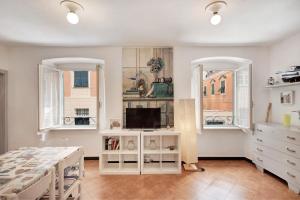 a bedroom with a bed and a tv and two windows at Oceane Paradise - Churchill in Levanto