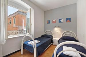 two beds in a room with a window at Oceane Paradise - Churchill in Levanto