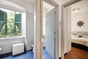 a bathroom with a toilet and a window and a bed at Oceane Paradise - Churchill in Levanto +17 photos