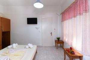 a white room with a bed and a television at Nikiana Club - Studio 1 in Nikiana +14 photos