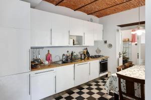 a kitchen with white cabinets and a checkered floor at Casa romantica in Ispra