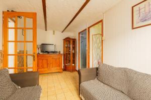 a living room with two couches and a tv at Maison à Saint-Blimont in Saint-Blimont