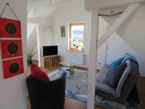 a living room with a bed and chairs in a room at Straussi´s Loft in Tuttlingen