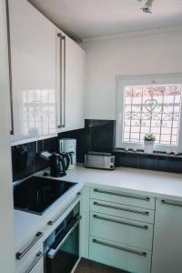 a kitchen with white cabinets and a sink and a window at Haus Piratennest in Grömitz