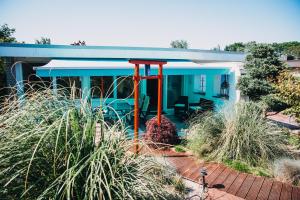 a blue house with red poles in a garden at Haus Piratennest in Grömitz