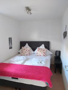 a bedroom with a bed with red sheets and pillows at Haus Piratennest in Grömitz