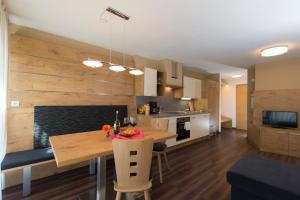 a kitchen and living room with a wooden wall at Alpenblick Nr 6 in Campo Tures