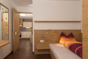 a bedroom with a bed with a colorful pillow on it at Alpenblick Nr 6 in Campo Tures