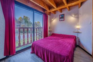 a bedroom with a bed and a large window at Apt Framboise Les Monts d'olmes in Montferrier