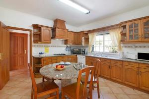 a kitchen with a table with a bowl of fruit on it at Casa do Barrocal in Almancil