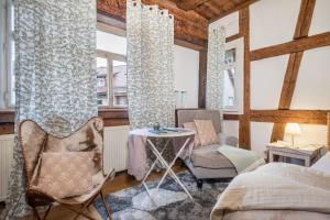 a bedroom with two chairs and a table and two windows at Lemkamp groß in Markdorf