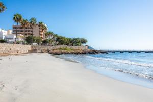 a beach in front of the ocean with a pier at Casa Antonia in Cala Millor