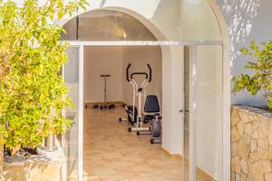 a gym with exercise equipment in a room with trees at Villa Bellver in Palma de Mallorca