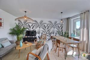 a living room with a table and a dining room at Le passé composé in Ploubazlanec