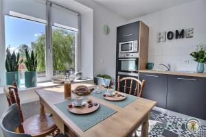 a kitchen with a wooden table with chairs and a dining room at Le passé composé in Ploubazlanec