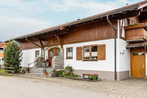 a white house with wooden accents at Gästehaus Erd - Fewo Grünten in Wertach