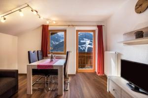 a living room with a dining room table and a television at Golserhof Kristall in Cadipietra +22 photos