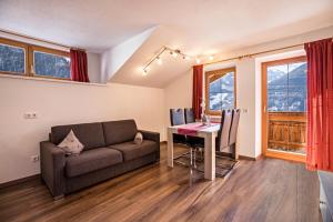 a living room with a couch and a desk with a computer at Golserhof Kristall in Cadipietra