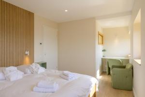 a bedroom with a white bed with towels on it at Refuge Mil100 Chalet-spa Luxe 5 in Metzeral