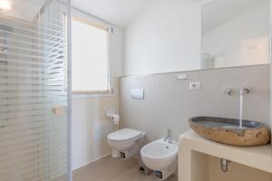 a bathroom with a sink and a toilet at Residenza Cormorani 2 in Golfo Aranci +20 photos