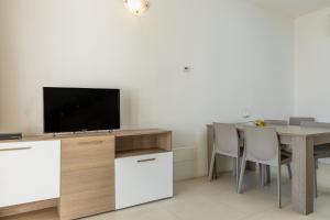 a living room with a table and a television at Residenza Cormorani 2 in Golfo Aranci