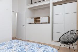a bedroom with a bed and a chair at Residenza Cormorani 2 in Golfo Aranci