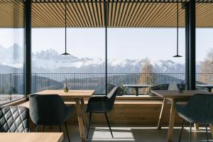 a restaurant with tables and chairs and a large window at anders mountain suites 1 in Brixen +24 photos