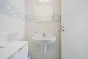 a white bathroom with a sink and a mirror at Villa Terry in Ostuni +19 photos
