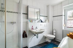 a white bathroom with a sink and a toilet at Li-Do-Bo 01 in Herdwangen-Schönach +21 photos