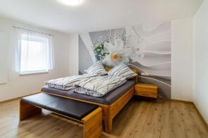 a bedroom with a bed with flowers on the wall at Li-Do-Bo 01 in Herdwangen-Schönach